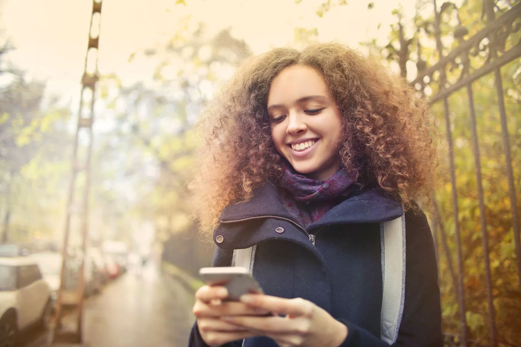 A patient smiling as she reads a text message on her phone